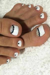 White pedicure with black rhinestones