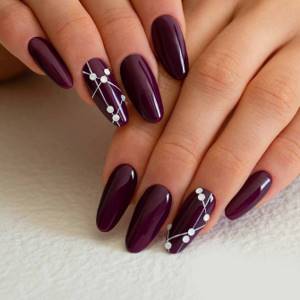 Burgundy nail extensions with white dots and stripes