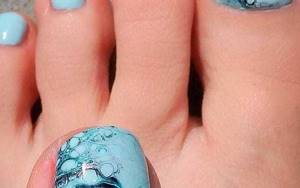 Pedicure design at sea with watercolor stains and accent nails with glitter