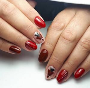 Geometric designs on red and nude nail extensions