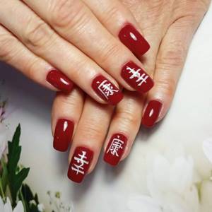 red manicure with hieroglyphs