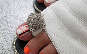 Fashionable white and orange pedicure with geometry