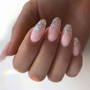 Delicate manicure stretching with glitter on tips