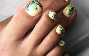 Warm, fashionable light yellow pedicure with foil