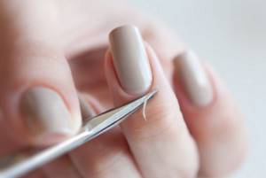 Removing cuticle with scissors.